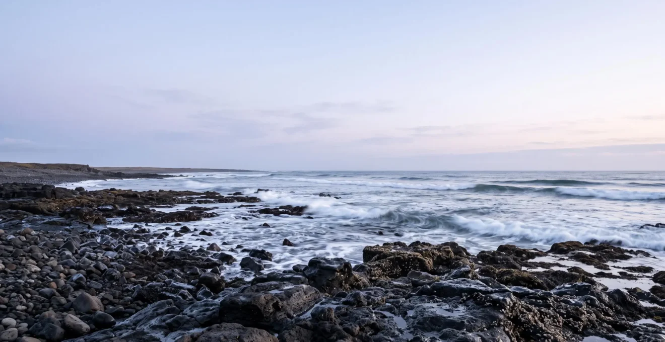 Wide view of a rugged Atlantic coastline at dawn with rhythmic waves symbolizing the connection between ocean patterns and sleep cycles