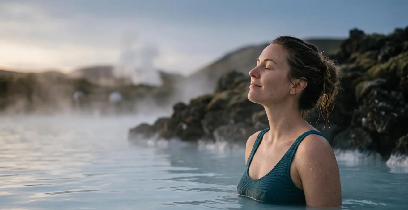 A traveler relaxing in a steaming mineral-rich geothermal pool surrounded by natural volcanic rock at dusk